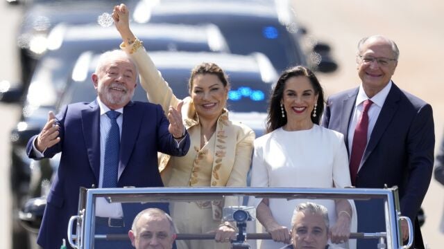 El presidente electo Luiz Inácio Lula da Silva, a la izquierda, su esposa Rosangela Silva, segunda por la izquierda, el vicepresidente electo Geraldo Alckmin, a la derecha, y su esposa Maria Lucia Ribeiro, viajan en un coche descubierto hacia el Congreso para su ceremonia de investidura, en Brasilia