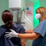 Una mujer con ayuda de una enfermera se hace una mamografía gratuita en Quirónsalud Infanta Luisa por el Día Internacional del Cáncer de Mama