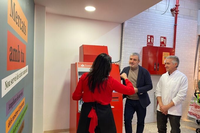 El primer teniente de alcalde de Barcelona, Jaume Collboni, visita el cajero automático en el Mercat del Besòs junto a paradistas