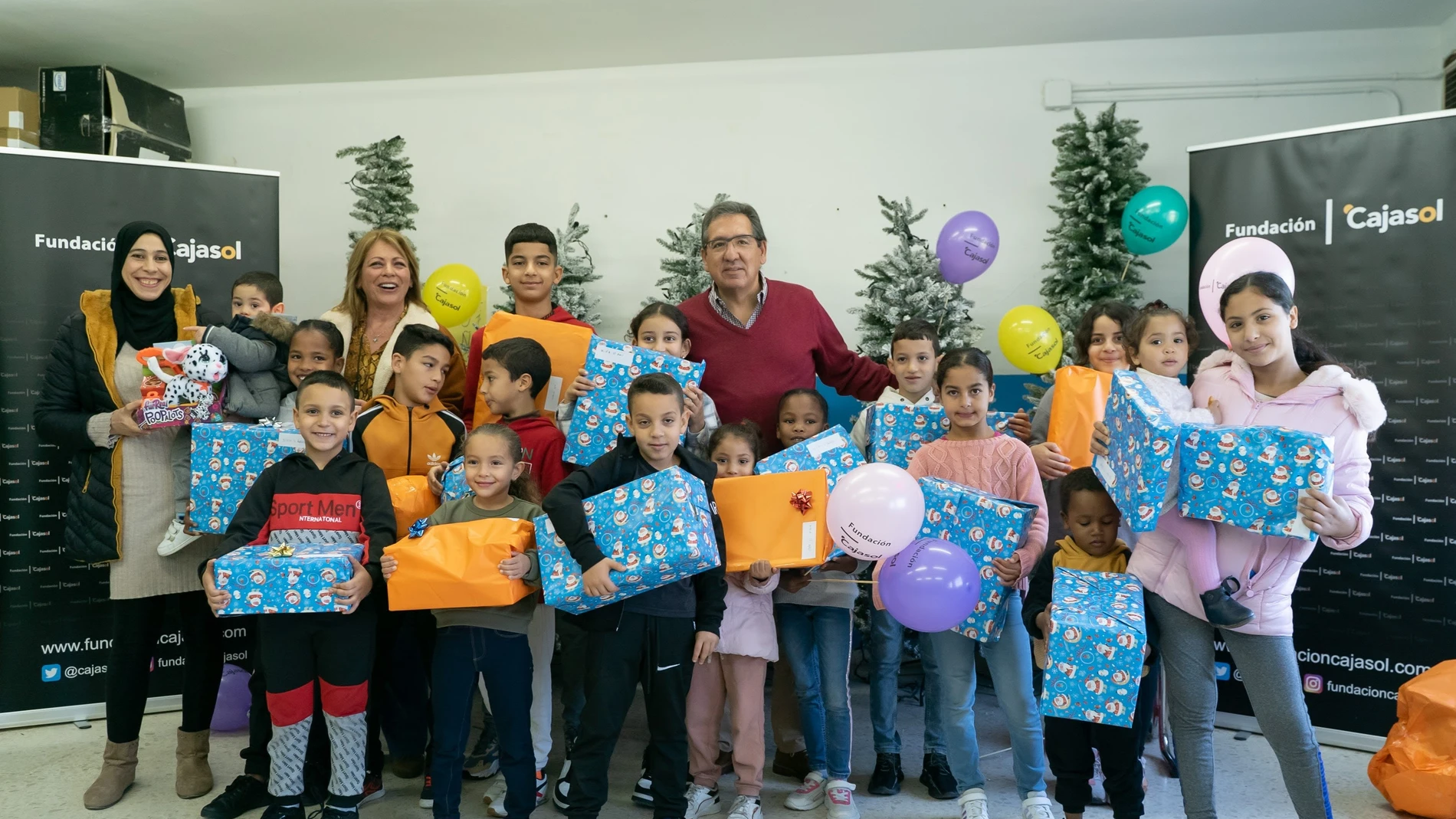 El presidente de la Fundación Cajasol, Antonio Pulido, entrega juguetes a los niños de la ONG Cooperación Internacional en el marco de la campaña 'Un juguete, una ilusión'