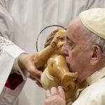 El Santo Padre besa una imagen del Niño Jesús, ayer, durante la misa