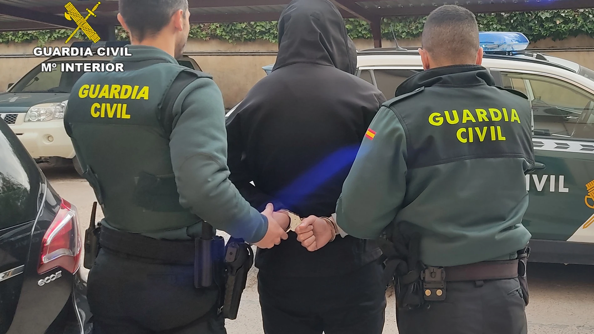 El detenido, esposado, junto a dos agentes de la Guardia Civil
