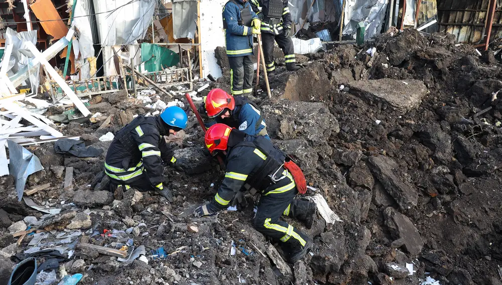Rescatistas ucranianos trabajan en el lugar de un mercado local alcanzado por un bombardeo en la localidad de Shevchenkove, región de Járkiv