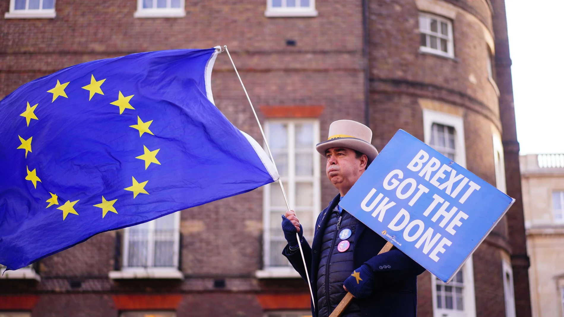 Un manifestante anti-Brexit sostiene un cartel y la bandera de la UE durante una protesta en Londres