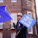 Un manifestante anti-Brexit sostiene un cartel y la bandera de la UE durante una protesta en Londres