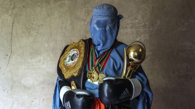 Una luchadora afgana de artes marciales mixtas posa para una foto con sus trofeos en Kabul, Afganistán