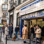 Largas colas a las puertas de la administración de lotería de Doña Manolita este jueves en Madrid, en la víspera de celebración del Sorteo de "El Niño"
