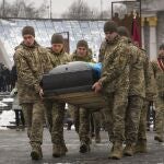Militares ucranianos trasaldadan el féretro de un compañero fallecido en la Plaza de la Independencia de Kyiv
