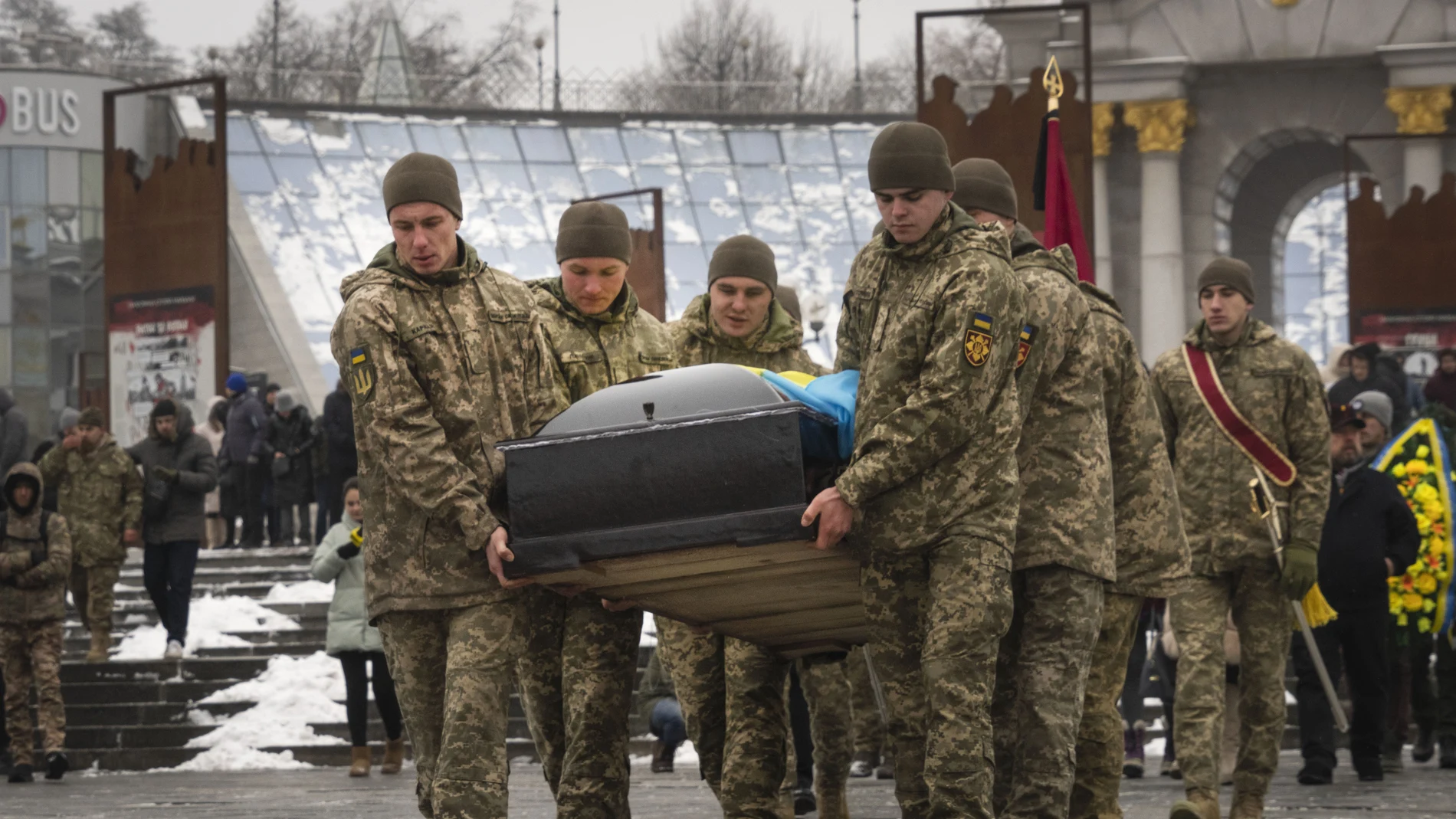 Militares ucranianos trasaldadan el féretro de un compañero fallecido en la Plaza de la Independencia de Kyiv