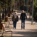 Dos jubilados pasean por un parque de Moratalaz (Madrid)