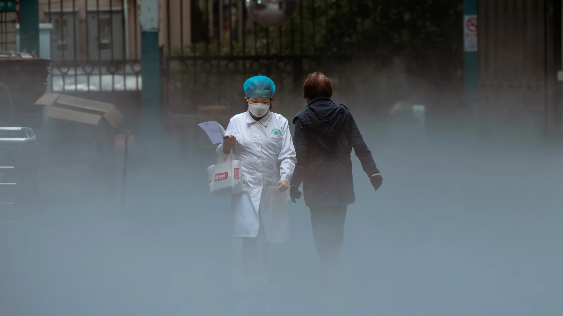 Un personal médico sale de la parte mortuoria de un hospital mientras otra persona acaba de entrar en las instalaciones en Shanghái