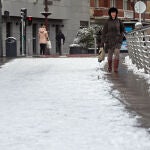 Una mujer camina por una calle cubierta de nieve, a 18 de enero de 2023, en Burgos