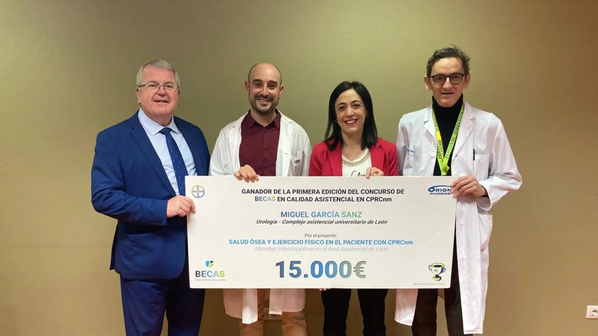 El urólogo del Complejo Asistencial Universitario de León (Caule), Miguel García (2I), recibe la beca del concurso en calidad asistencial de Bayer y Orión Farma de manos de María Jesús Campos, del Departamento Médico de Bayer (2D)