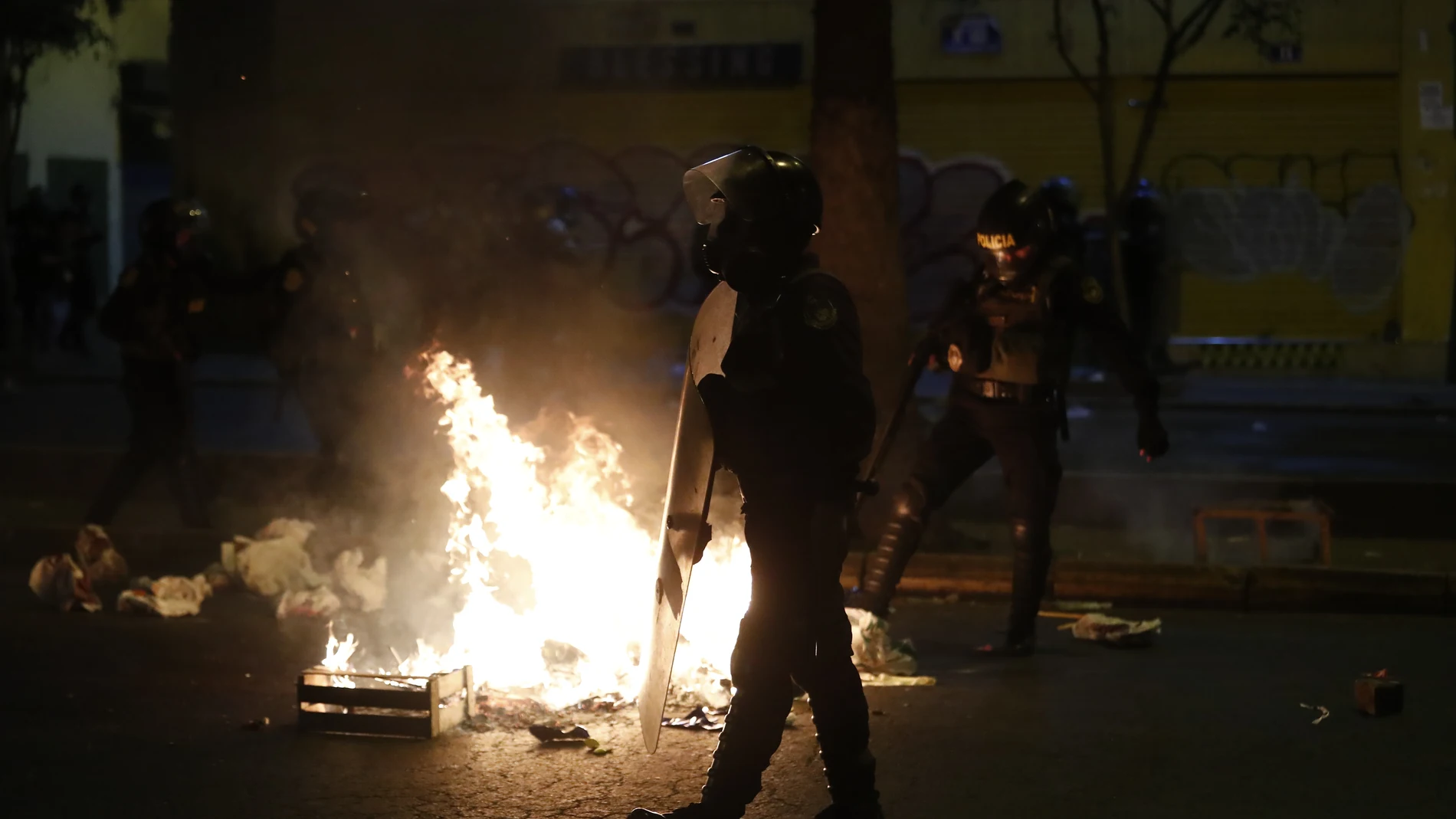 Miembros de la Policía intentan controlar una fogata sobre una vía, durante una nueva marcha antigubernamental en Lima