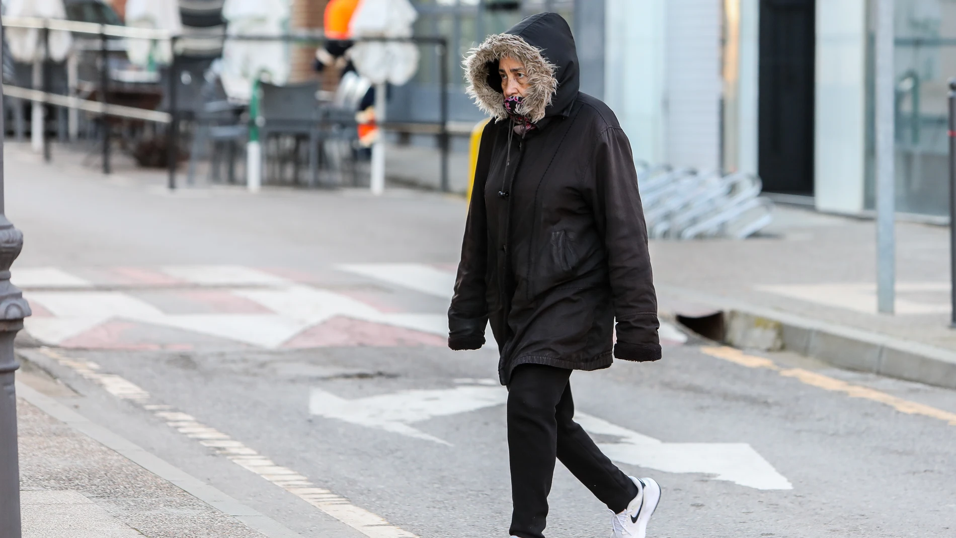 Una mujer pasea por una calle con ropa de abrigo