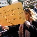 Una mujer sostiene una cartulina con un lema defendiendo el islam, en el sitio donde un hombre de origen marroquí asesinó al sacristán Diego Valencia de la iglesia de la Palma en Algeciras (Cádiz) en la noche de ayer. EFE/A.Carrasco Ragel.