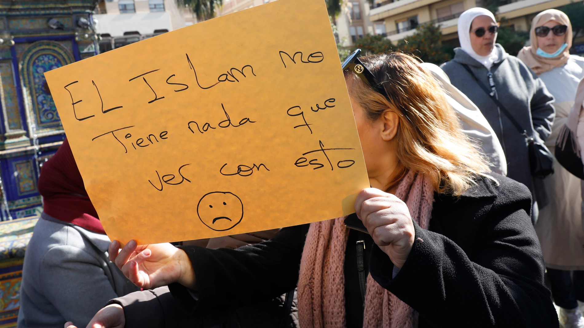 Una mujer sostiene una cartulina con un lema defendiendo el islam, en el sitio donde un hombre de origen marroquí asesinó al sacristán Diego Valencia de la iglesia de la Palma en Algeciras (Cádiz) en la noche de ayer. EFE/A.Carrasco Ragel.
