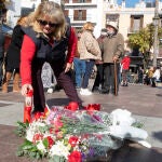 Una mujer coloca una vela en el lugar en el que falleció el sacristán de la iglesia de La Palma, en Algeciras