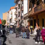 Vecinos, efectivos sanitarios y fuerzas de seguridad en la calle junto al bloque de viviendas de la calle Villanueva de los Castilleja, en la barriada de Isla Chica en Huelva