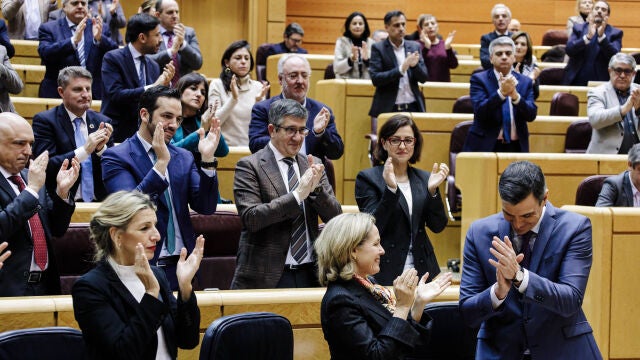 La vicepresidenta segunda y ministra de Trabajo, Yolanda Díaz, aplaude con gesto serio al presidente del Gobierno, Pedro Sánchez