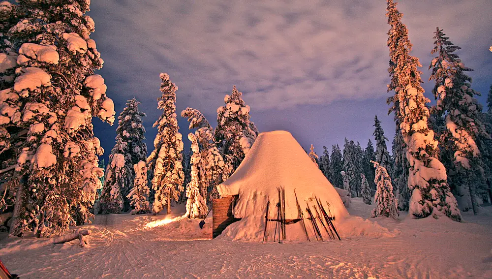 El techo de cristal calentado por láser se abre al cielo boreal, justo encima de la cama