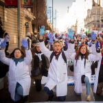 Varias personas con batas blancas y guantes azules protestan durante una marcha convocada por médicos y pediatras de Atención Primaria
