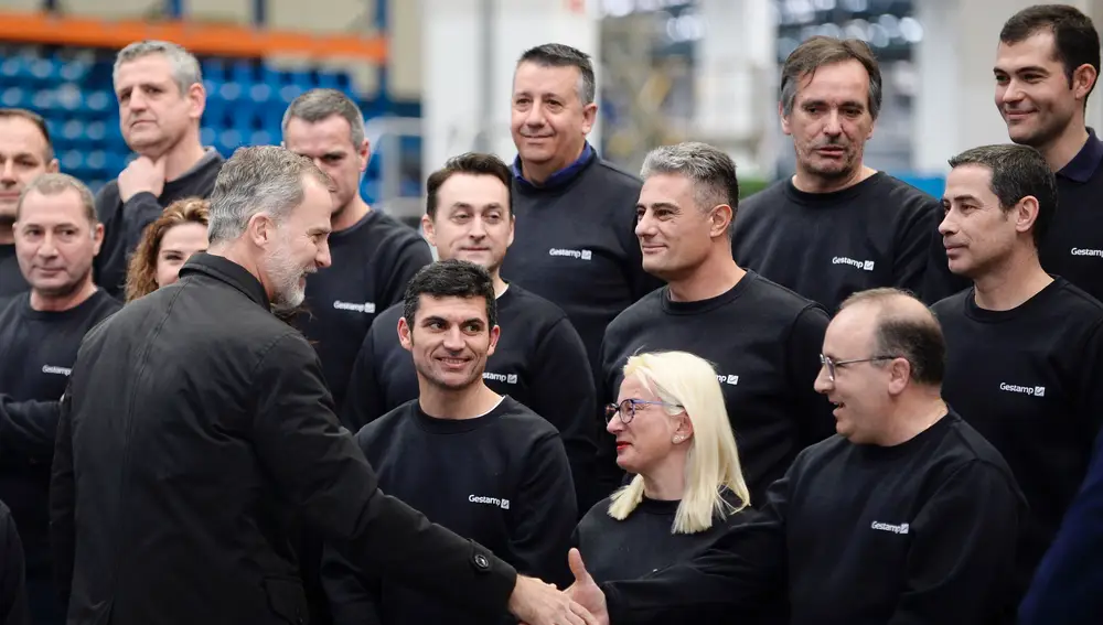 El rey Felipe VI (i) saluda a un grupo de trabajadores durante su visita a la planta de Gestamp, grupo internacional dedicado al diseño, desarrollo y fabricación de componentes metálicos para automóviles, con motivo de su 25 aniversario, este viernes, en Palencia
