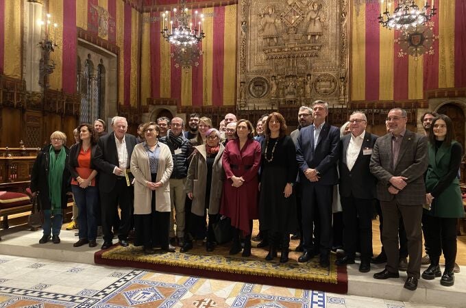 Representantes de los grupos municipales de Barcelona que han apoyado el plan de usos del Eixample junto a vecinos y comerciantes del distrito tras la aprobación de la regulación en el pleno extraordinario