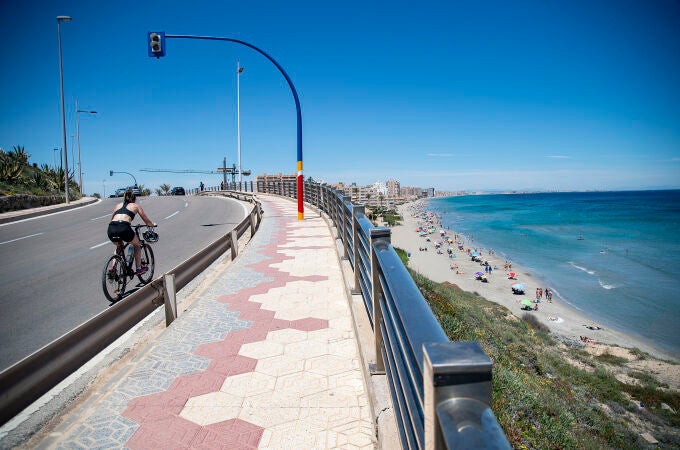 Una ciclista circula cerca de la Playa Galúa, en la Manga del Mar Menor, a 16 de abril de 2021, en Cartagena, Región de Murcia (España)