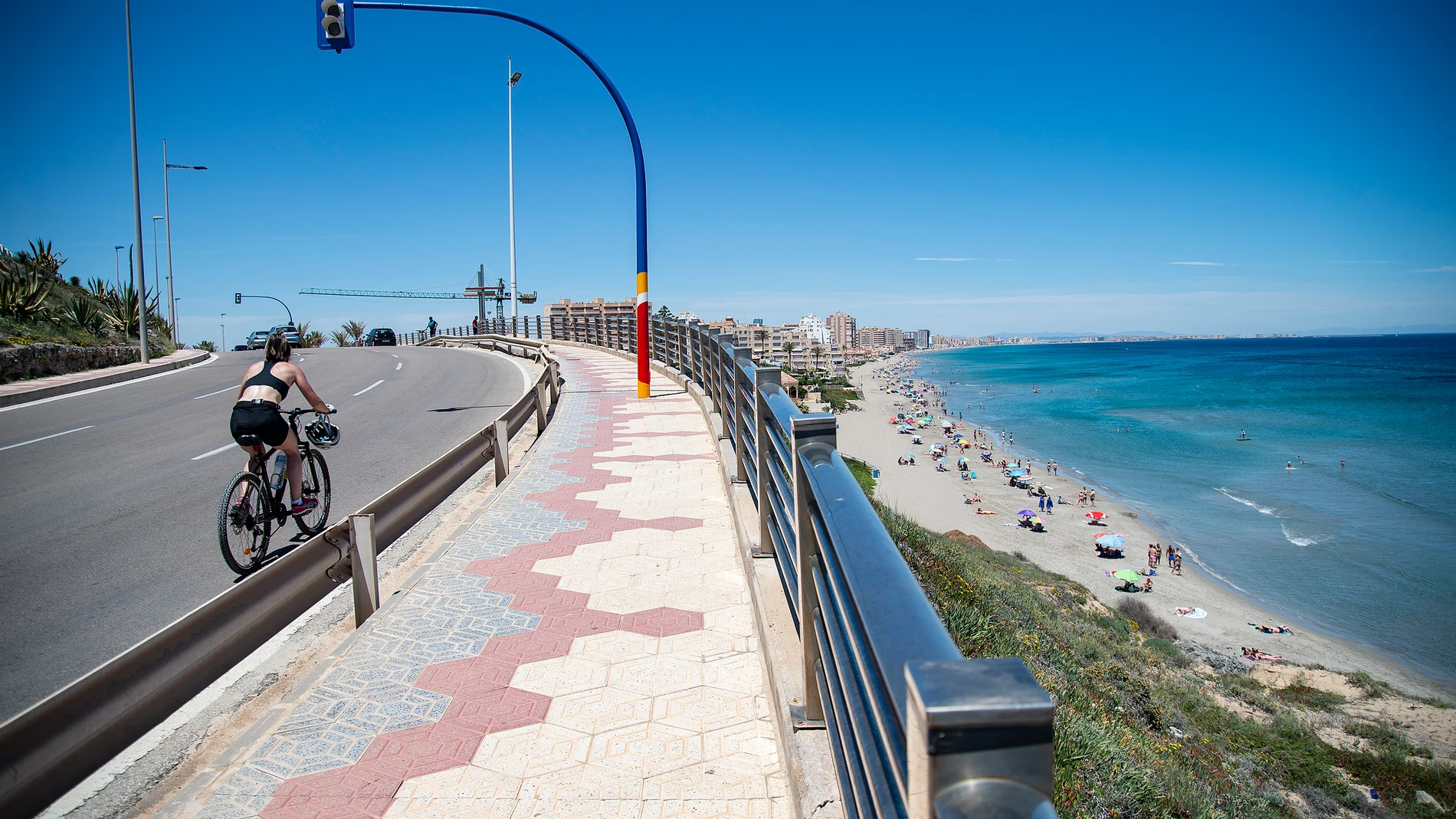 Una ciclista circula cerca de la Playa Galúa, en la Manga del Mar Menor, a 16 de abril de 2021, en Cartagena, Región de Murcia (España)