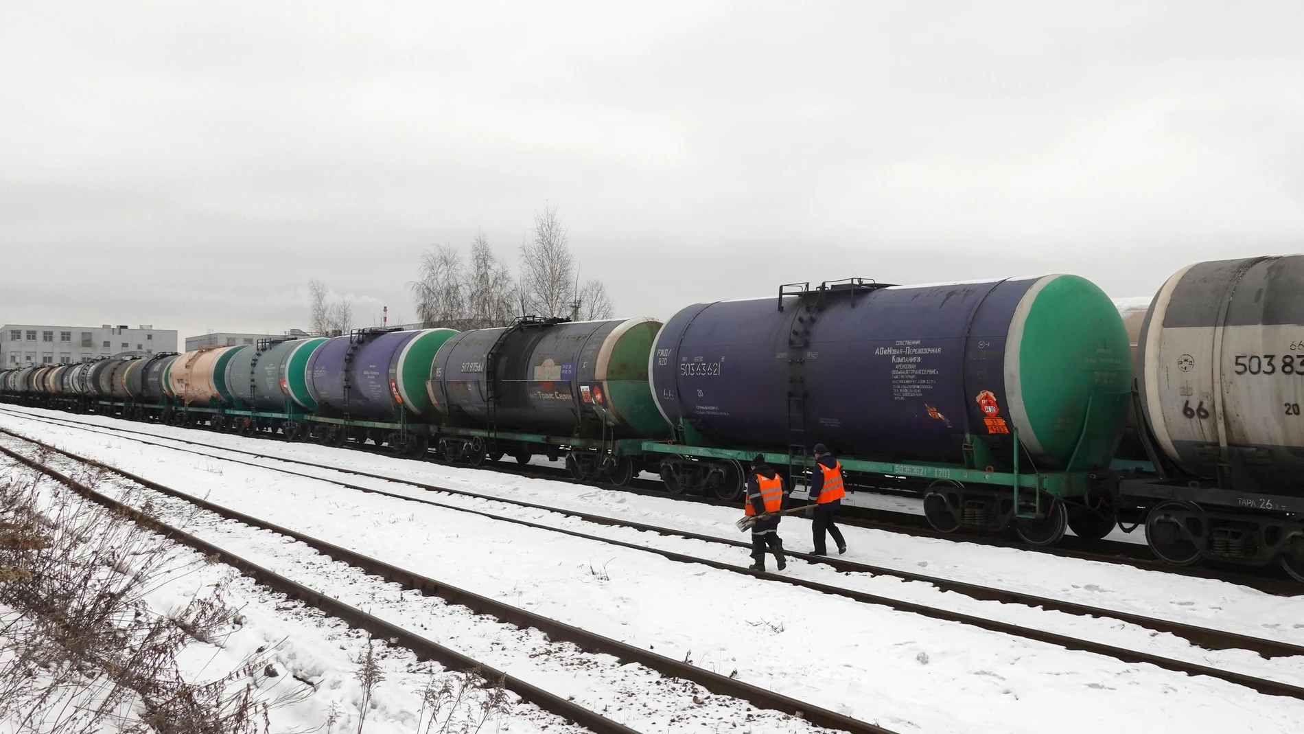 Moscow (Russian Federation), 06/02/2023.- Workers walk in front of railway tankers carrying oil products outside Moscow, Russia, 06 February 2023. On 24 February 2022 Russian troops entered Ukrainian territory in what the Russian president declared a 'Special Military Operation', resulting in multiple sanctions against Russia, including sanctions against the oil industry. (Rusia, Moscú) EFE/EPA/MAXIM SHIPENKOV 