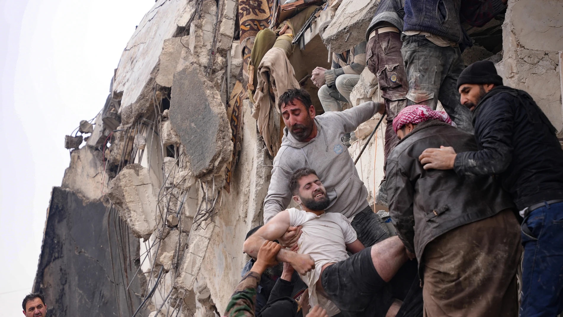 Vecinos rescatan a un superviviente entre los escombros de un edificio derrumbado en la ciudad de Jandaris, en Siria
