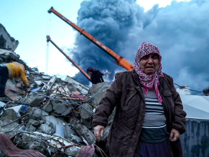Una mujer reacciona mientras el personal de emergencia busca víctimas en el lugar donde se derrumbó un edificio tras un terremoto en Iskenderun, distrito de Hatay, Turquía