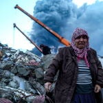 Una mujer reacciona mientras el personal de emergencia busca víctimas en el lugar donde se derrumbó un edificio tras un terremoto en Iskenderun, distrito de Hatay, Turquía