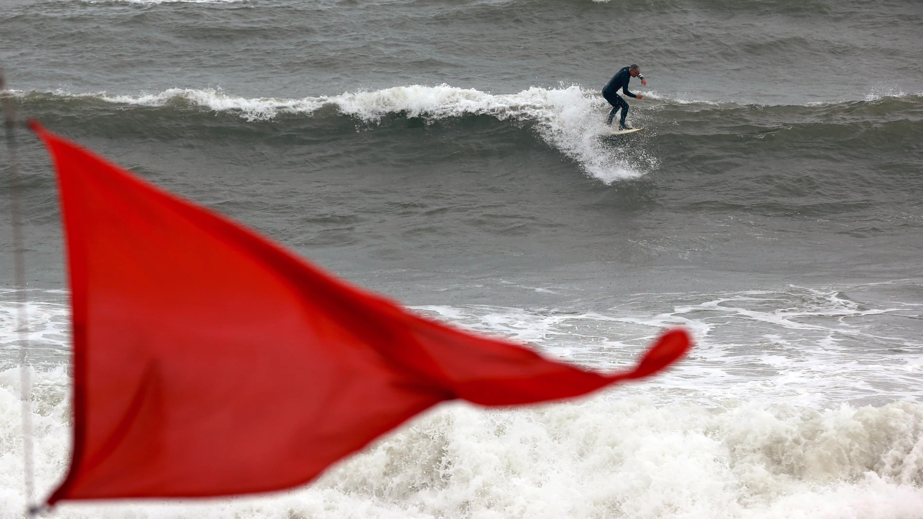 -FOTODELDÍA- GRAFCAT5806. BARCELONA, 07/02/2023.- Un hombre practica surf en la playa de la Barceloneta de Barcelona, este martes, cuando el fuerte oleaje por el temporal de Levante, con olas de hasta 4 metros, está afectando a las playas del litoral catalán, y esta mañana ha empezado a nevar por encima de los 600 metros en zonas de la Garrotxa, el Ripollès y norte de Osona, nevada que es más intensa en las zonas altas del Pirineo Oriental. EFE/Toni Albir