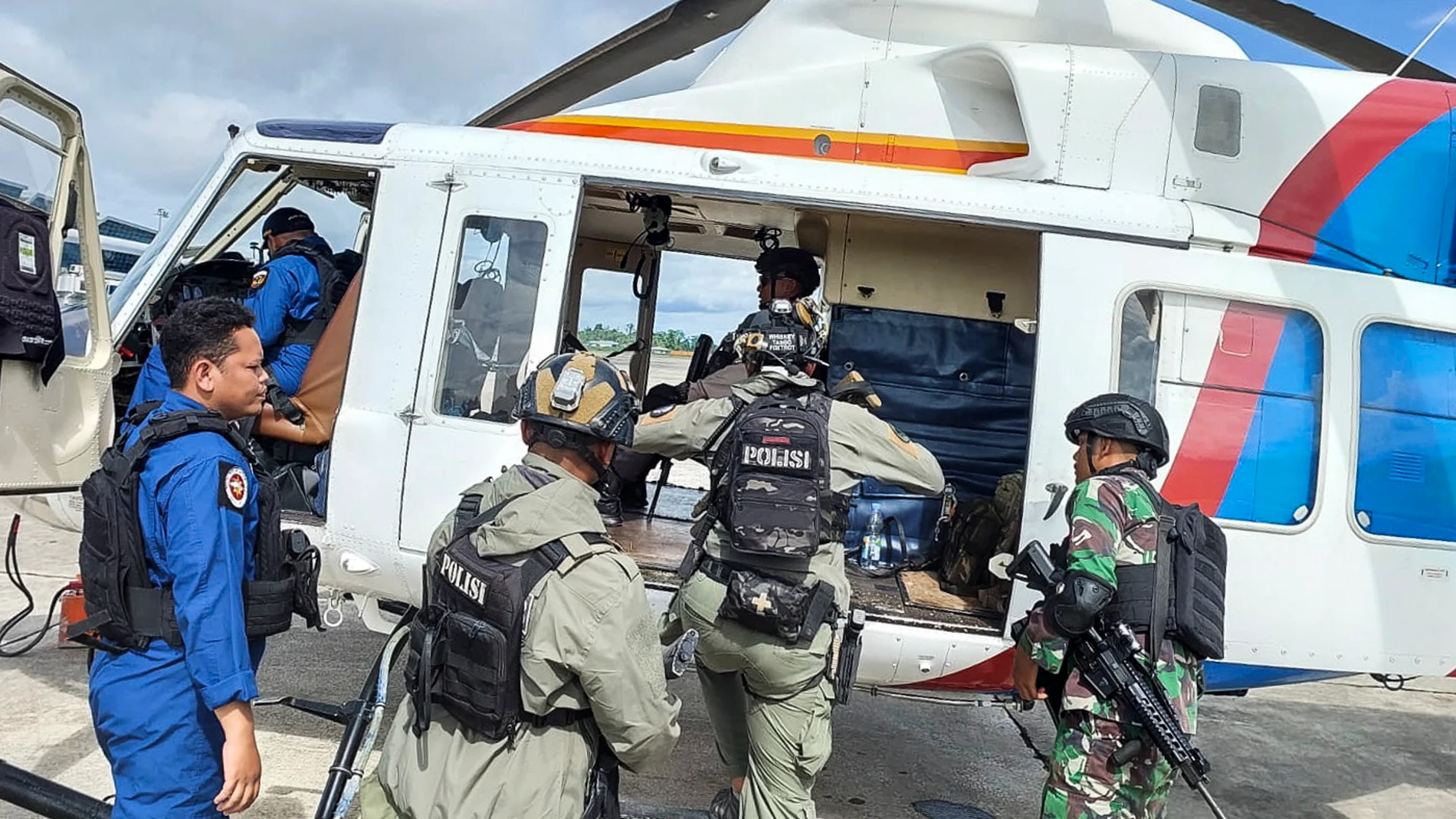 Timika (Indonesia), 08/02/2023.- A handout photo made available by Papua Police Headquarters shows Indonesian police and military personnel boarding an helicopter during a search and rescue operation for Susi Air pilot and passangers at an airport in Timika, Papua, Indonesia 08 February 2023. According to the police, a joint security forces from the police and the military have evacuated workers and passangers of Susi Air PK-BVY that were held hostage by separatist forces while the operation to locate the New Zealand pilot is still ongoing. An aircraft Susi Air PK-BVY was torched as the pilot and passangers were taken hostage by separatist group in Nduga district, Papua on 07 February. (Nueva Zelanda) EFE/EPA/PAPUA POLICE HEADQUARTERS / HANDOUT HANDOUT HANDOUT EDITORIAL USE ONLY/NO SALES