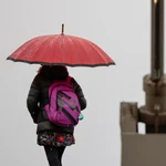 Una mujer se protegen de la lluvia con un paraguas