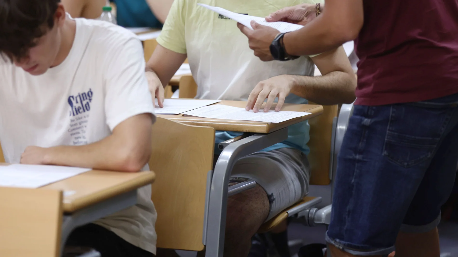 Un profesor reparte los exámenes de la EVAU