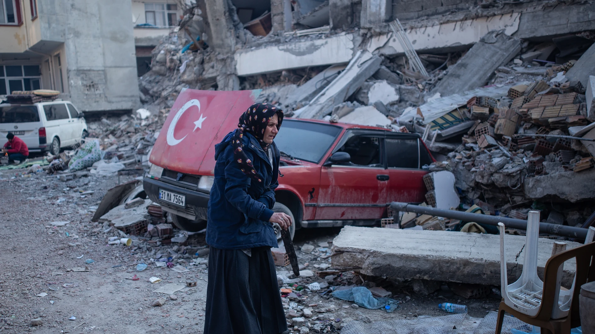 Hatay (Turkey), 13/02/2023.- A woman stands near the rubble of a collapsed building and the wreckage of a car in the aftermath of a powerful earthquake in Hatay, Turkey, 13 February 2023. More than 35,000 people have died and thousands more are injured after two major earthquakes struck southern Turkey and northern Syria on 06 February. Authorities fear the death toll will keep climbing as rescuers look for survivors across the region. (Terremoto/sismo, Siria, Turquía, Estados Unidos) EFE/EPA/STR 