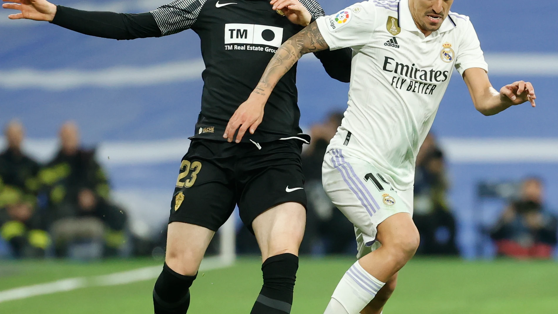 MADRID, 15/02/2023.- El centrocampista del Real Madrid Dani Ceballos (d) escapa de Carlos Clerc, del Elche, durante el partido de LaLiga Santander que disputan este miércoles el Real Madrid y el Elche CF en el estadio Santiago Bernabéu. EFE/Mariscal