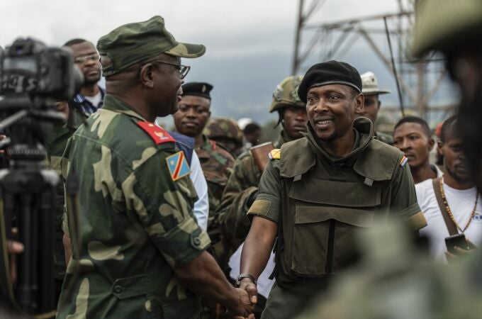 Willy Ngoma, portavoz del M23, estrecha la mano del comandante de la Fuerza Regional de la CAO tras la retirada de la guerrilla de Kibumba, este 23 de diciembre.