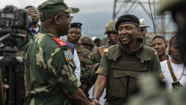 Willy Ngoma, portavoz del M23, estrecha la mano del comandante de la Fuerza Regional de la CAO tras la retirada de la guerrilla de Kibumba, este 23 de diciembre.