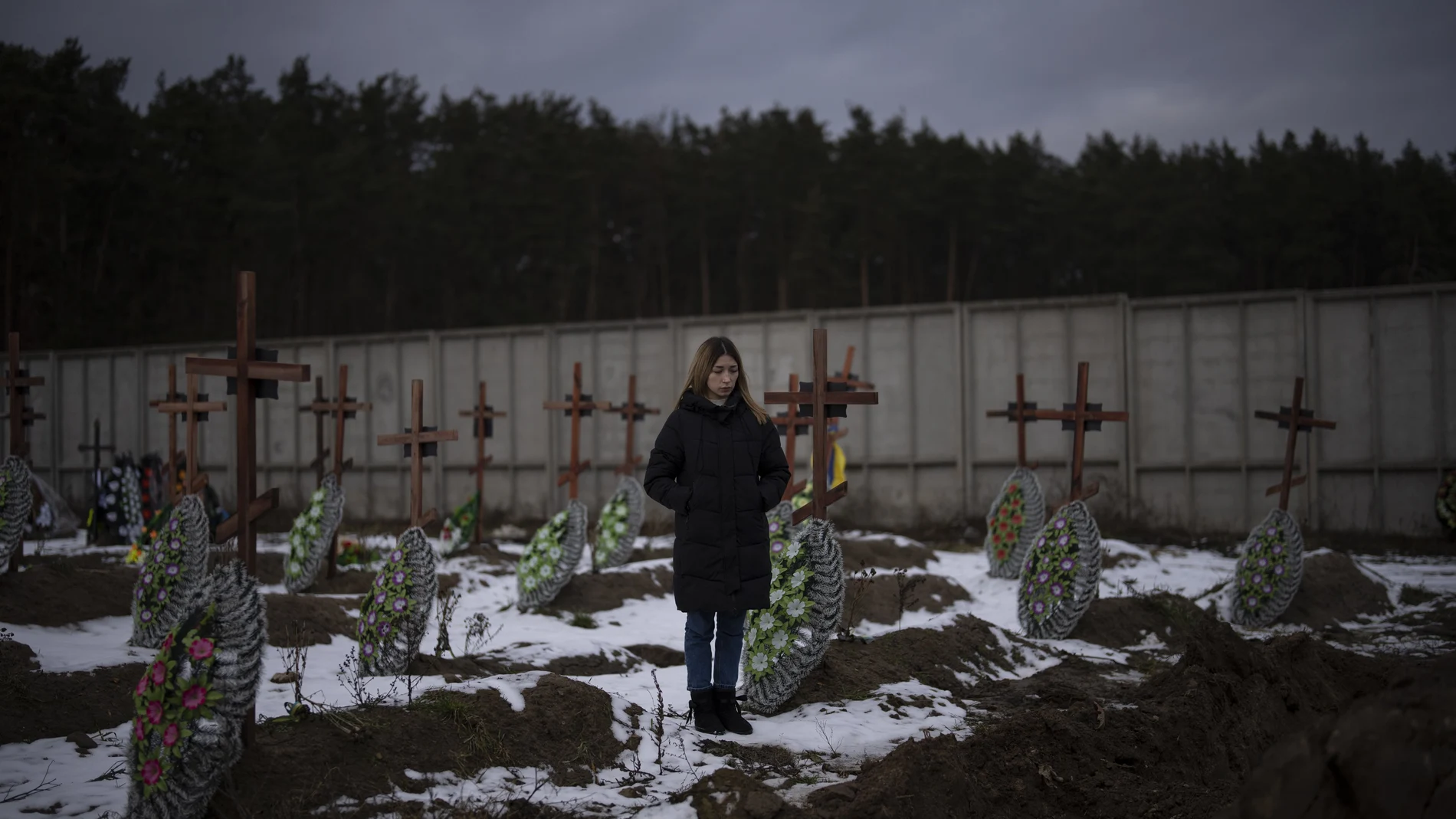 Una joven ucraniana acude al cementerio de Bucha, escenario de una de las mayores matanzas del Ejército ruso durante el primer año de invasión