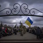 Ucranianos se arrodillan durante el funeral de un soldado en Brovary, cerca de Kyiv