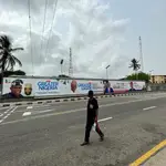 Un ciudadano de Lagos camina junto a los carteles electorales del APC. 