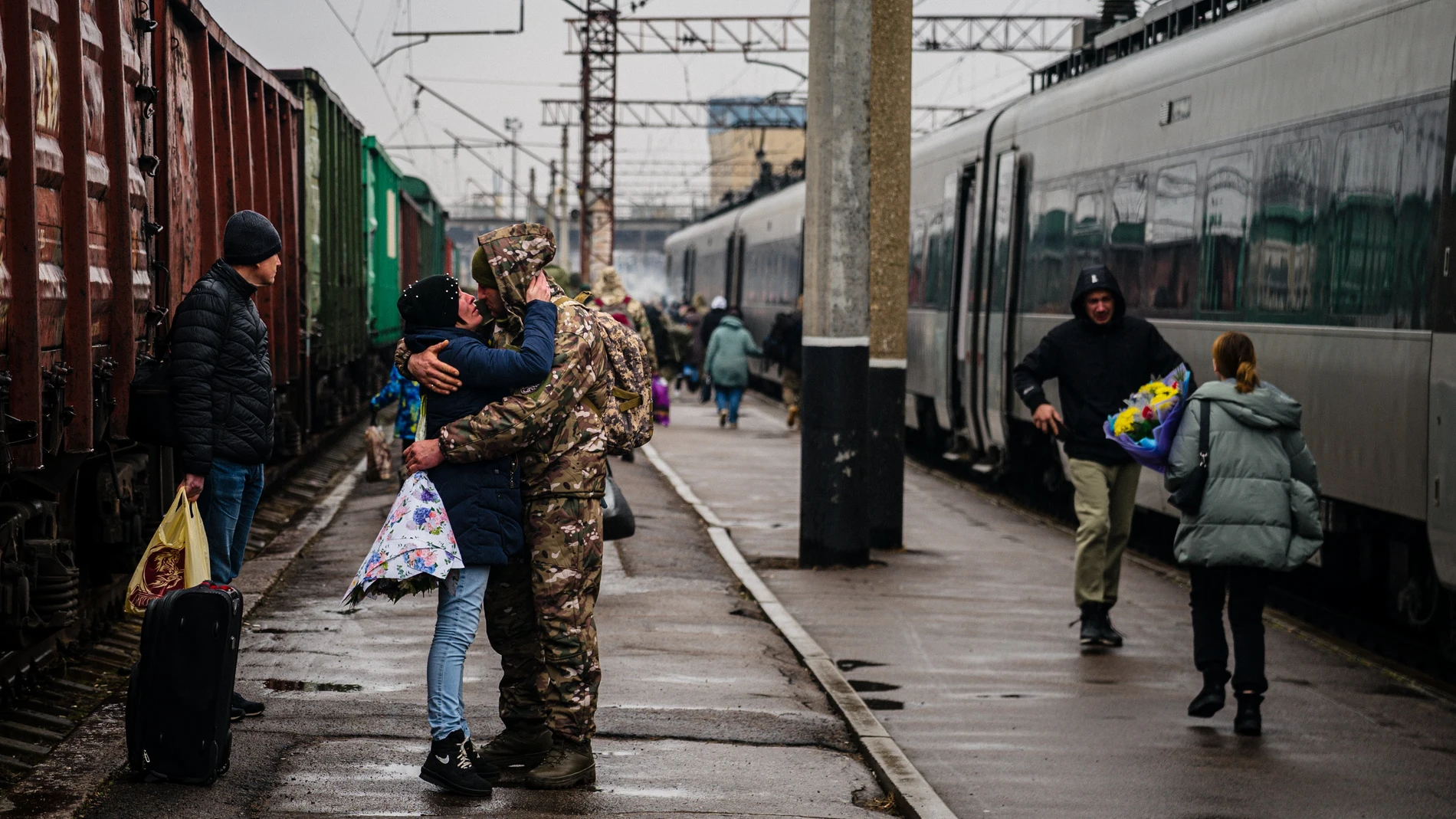 A Ukrainian serviceman embraces his wife as she arrives from Kyiv at the train station in Kramatorsk on February 26, 2023, amid the Russian invasion of Ukraine.