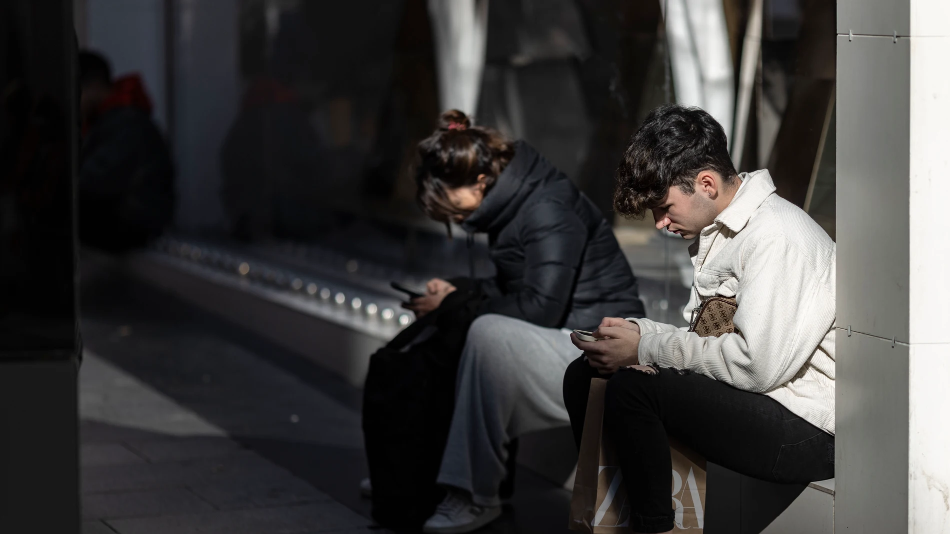 Gente usando sus teléfonos móviles en Madrid