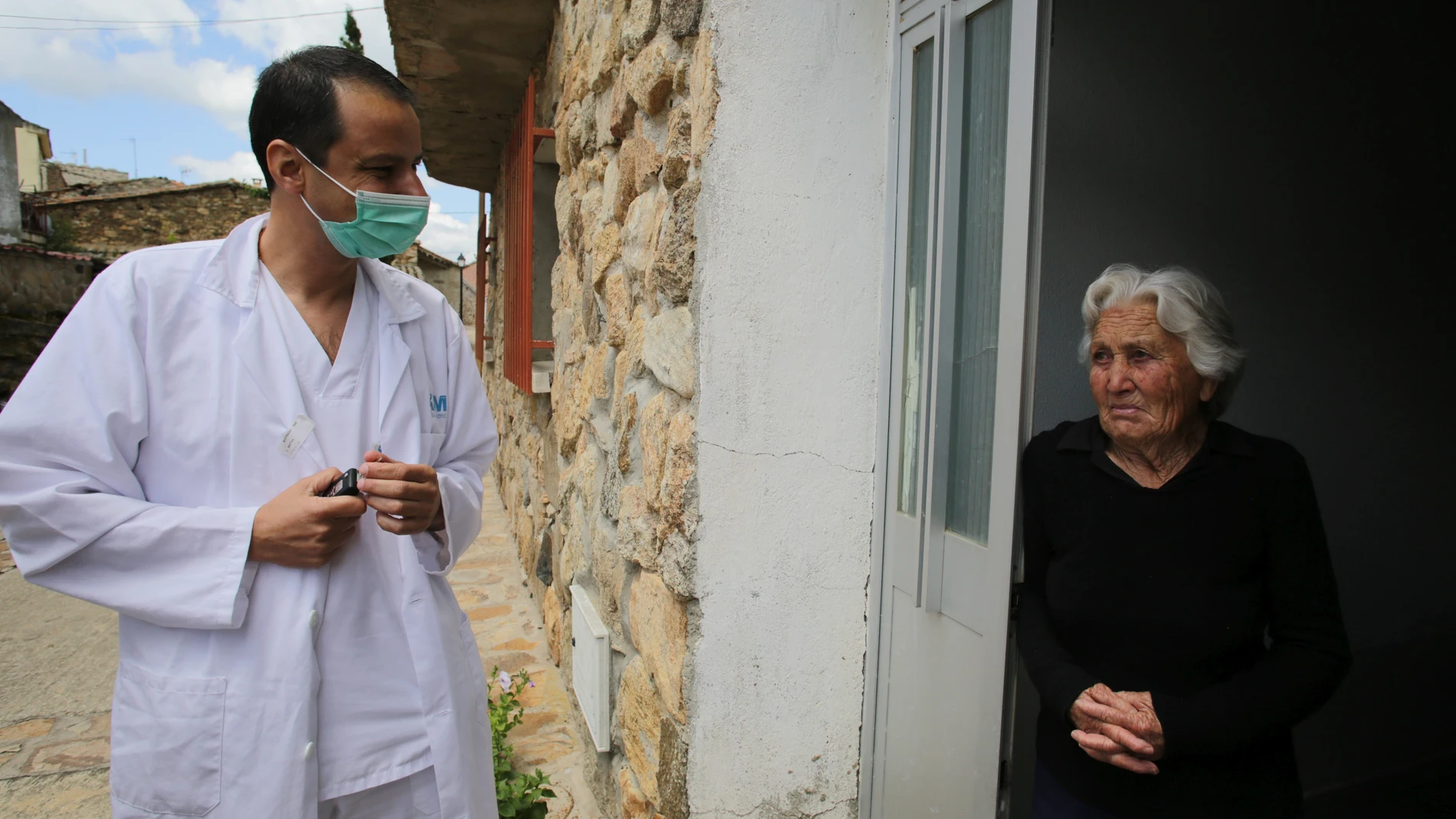 Un profesional sanitario acude a ver una vecina en un pueblo