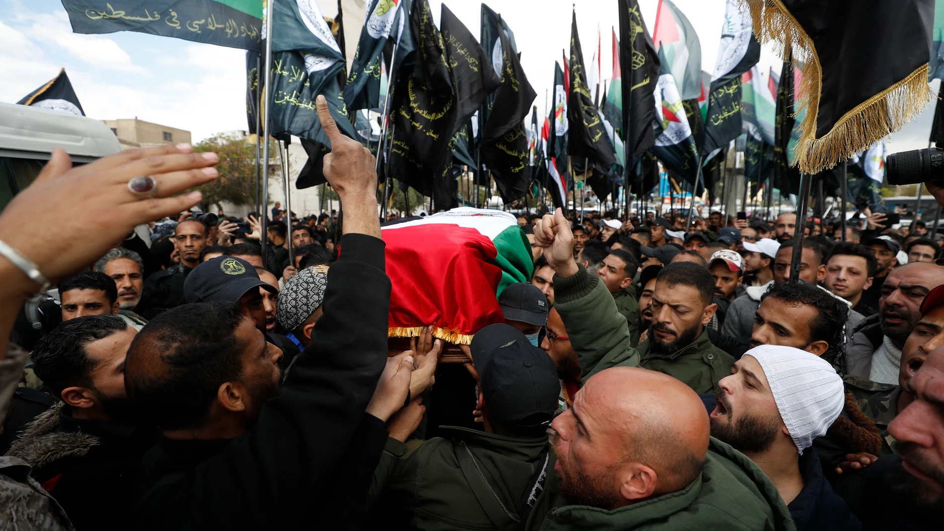 People attend the funeral of Ali Ramzi al-Aswad, a commander with the Palestinian militant group Islamic Jihad, in a Palestinian refugee camp of Yarmouk in Damascus, Syria, Monday, March 20, 2023. Al-Aswad was shot and killed Sunday outside his home in Yarmouk. Islamic Jihad group described the killing as an assassination by Israeli agents. There was no statement from Israel on the militant commander's death. (AP Photo/Omar Sanadiki)