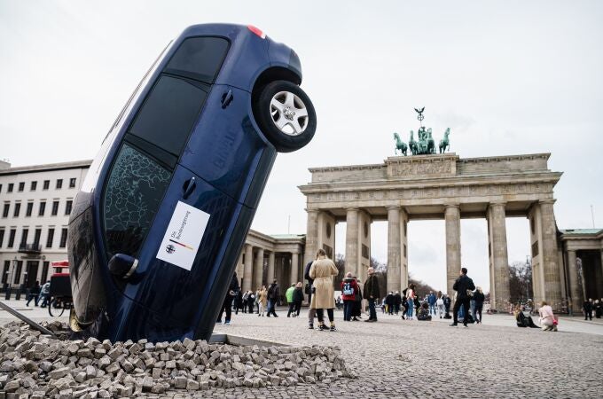 Berlín (Alemania), 22/03/2023.- Una instalación de Greenpeace muestra un todocamino que se estrelló contra el suelo ante la Puerta de Brandenburgo, como parte de una protesta contra el bloqueo alemán a una eliminación europea de los motores de combustión, en Berlín. Alemania